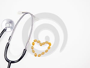 A stethascope and a heart of pills on a white background.