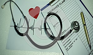 The Stethescope put on the Insurance Claim Form with heart rate wave drawing and red heart origami