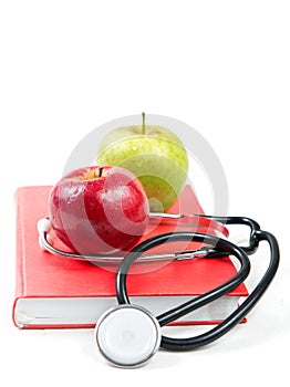 Stethoscope and apples on a book