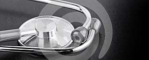 Stethoscope on black wooden background close up