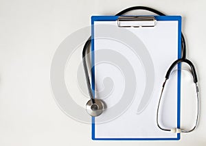 Stethoscope and blank clipboard isolated on white