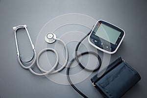 stethoscope with blood pressure measurement machine on dark grey background