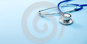 Stethoscope on blue background with empty space for text and title.