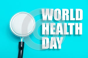 Stethoscope on blue background with text world health day