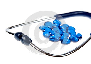 Stethoscope with blue pills isolaetd on white