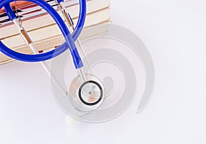 Stethoscope and books on white background.