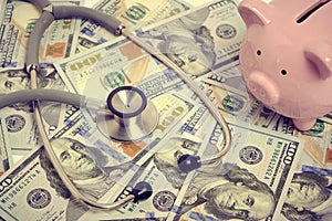 Stethoscope, bunch dollars and piggy bank, concept expensive medicine