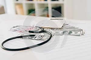 stethoscope calculator and banknotes on table in clinic health