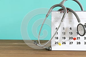 Stethoscope and calendar with green background, schedule to check up medical healthy concept