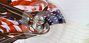 Stethoscope and cardiogram on table US flag