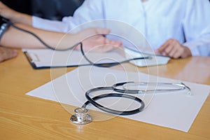 Stethoscope with clipboard and Laptop on desk Doctor working in