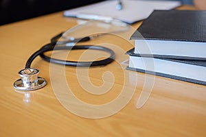 Stethoscope with clipboard and Laptop on desk Doctor working in