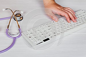 Stethoscope with clipboard and Laptop on desk,Doctor working in hospital writing a prescription,