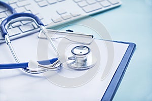Stethoscope with clipboard and Laptop on desk,Doctor working in hospital writing a prescription. Healthcare and medical