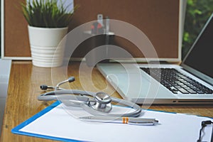 Stethoscope with clipboard and Laptop on desk,Doctor working in