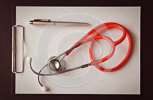 Stethoscope with clipboard and pen on desk