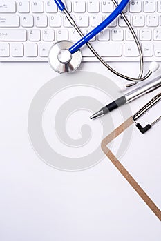 Stethoscope on computer keyboard on white background. Physician write medical case long term care treatment concept, top view,