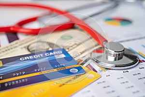 Stethoscope and credit card with US dollar banknotes on graph, Finance, Account, Statistics, Analytic research data and Business