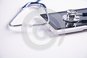 Stethoscope with digital tablet on white desk. Medical equipment. Space for your text