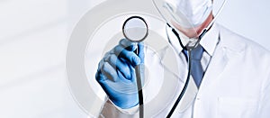 Stethoscope doctor medical background. Happy nurse in hospital uniform, blue gloves holding stethoscope  on