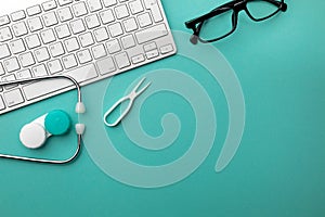 Stethoscope in doctors desk with notebook, pen, keyboard, mouse and pills