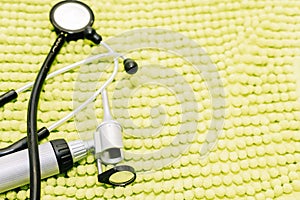 Stethoscope and ear watcher from a veterinary center on top of a green blanket