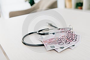 stethoscope and euro banknotes on table in clinic health