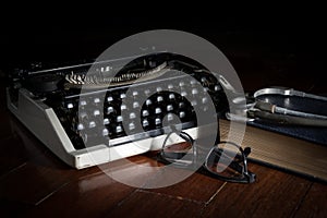 Stethoscope with eyeglasses book and typewriter.