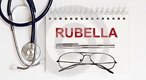 Stethoscope,glasses and pen with notepad with text RUBELLA