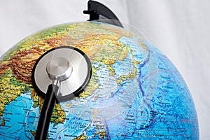 Stethoscope on a globe, planet disease concept