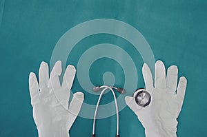 Stethoscope with gloves holding on blue surgery background in medical healthcare concept with copy space