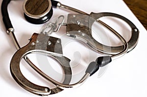 Stethoscope and handcuffs concept of medical malpractice photo