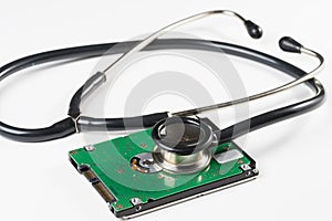 Stethoscope and hard disk drive on white background