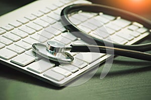 Stethoscope head lying on keyboard .PC repair fix laptops, desktops, netbooks  setup and service concept photo