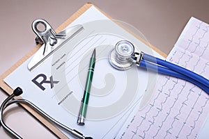 Stethoscope head and silver pen lying on cardiogram clipboard pad. Cardio therapeutist assistance, physician make cardiac physica