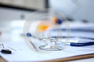 Stethoscope head and silver pen lying on medical application form