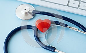 Stethoscope, Heart, Keyboard And Notepad On Tile Background