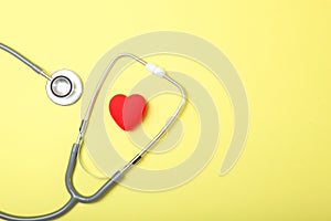 Stethoscope and heart on wooden background. Health, medicine