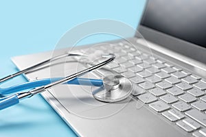 Stethoscope keyboard laptop computer isolated on blue background. Healthy Hardware. Telemedicine concept. Computer and gadget