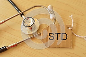 Stethoscope and label tag written with STD stands for SEXUALLY TRANSMITTED DISEASES