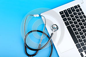 Stethoscope on a laptop on colored background. online medicine concept.