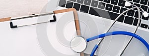Stethoscope on laptop computer keyboard with medical record clipboard design concept
