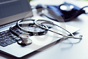 Stethoscope on laptop keyboard in doctor surgery