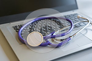 Stethoscope on laptop keyboard. Health care or IT security concept. Laptop repair concept. Computer repair concept Close-up view.