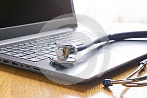 Stethoscope lay on  computer with pen and glasses, documents. work space
