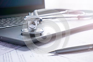 Stethoscope lay on  computer with pen and glasses, documents. work space