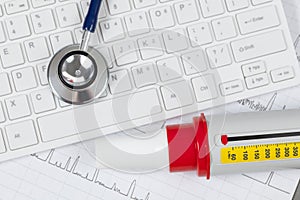 Stethoscope laying on a white computer keyboard