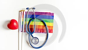 stethoscope on lgbtq rainbow flags pride symbol and red heart isolated on white background with copy space