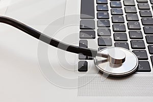 Stethoscope lies on the laptop keyboard.