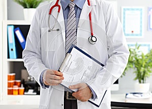 Stethoscope lying on male doctor chest in office
